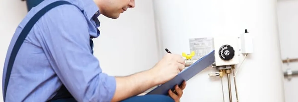 Water heater repair technician inspecting the unit and recording service notes in Fort Collins, CO